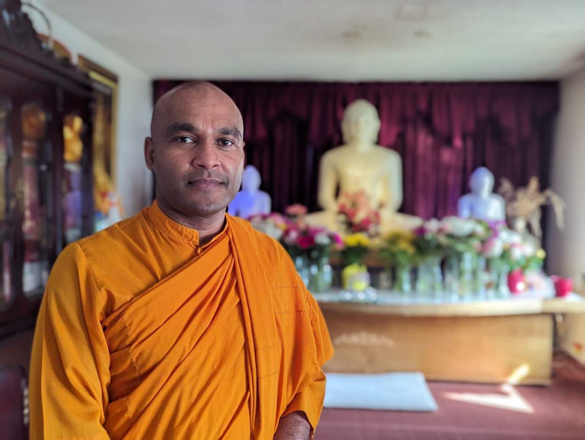 Monk Bhante Suneetha stands in the Buddhist temple.