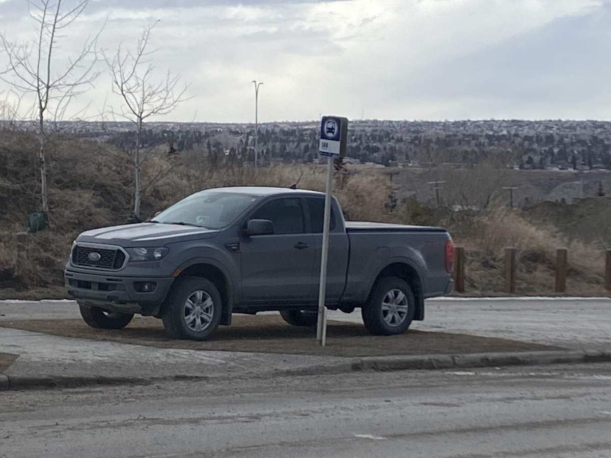 A truck parked on a Calgary Transit bus stop along Na’a Dr S.W.