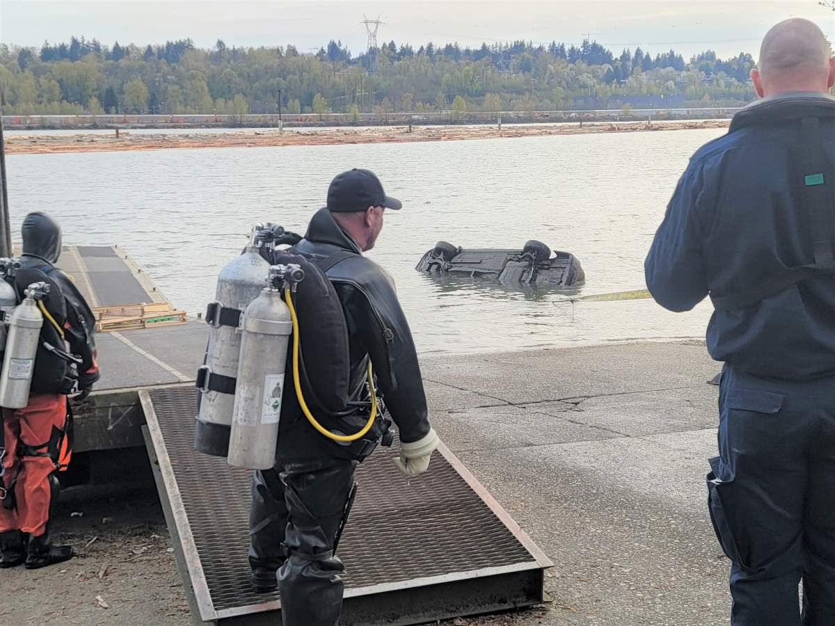An RCMP diver watches as police tow a stolen vehicle out of the Fraser River.