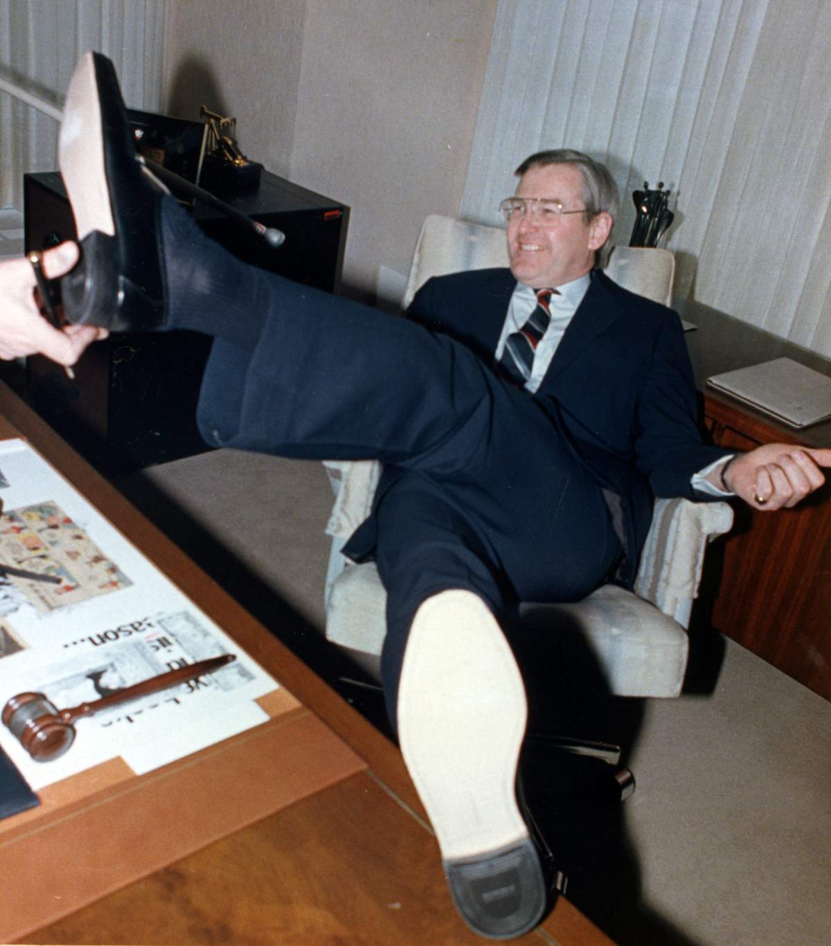 Finance Minister Michael Wilson puts his new shoe into the hand of a reporter during a photo session in his office on the eve of his budget in Ottawa on Feb. 9, 1988.
