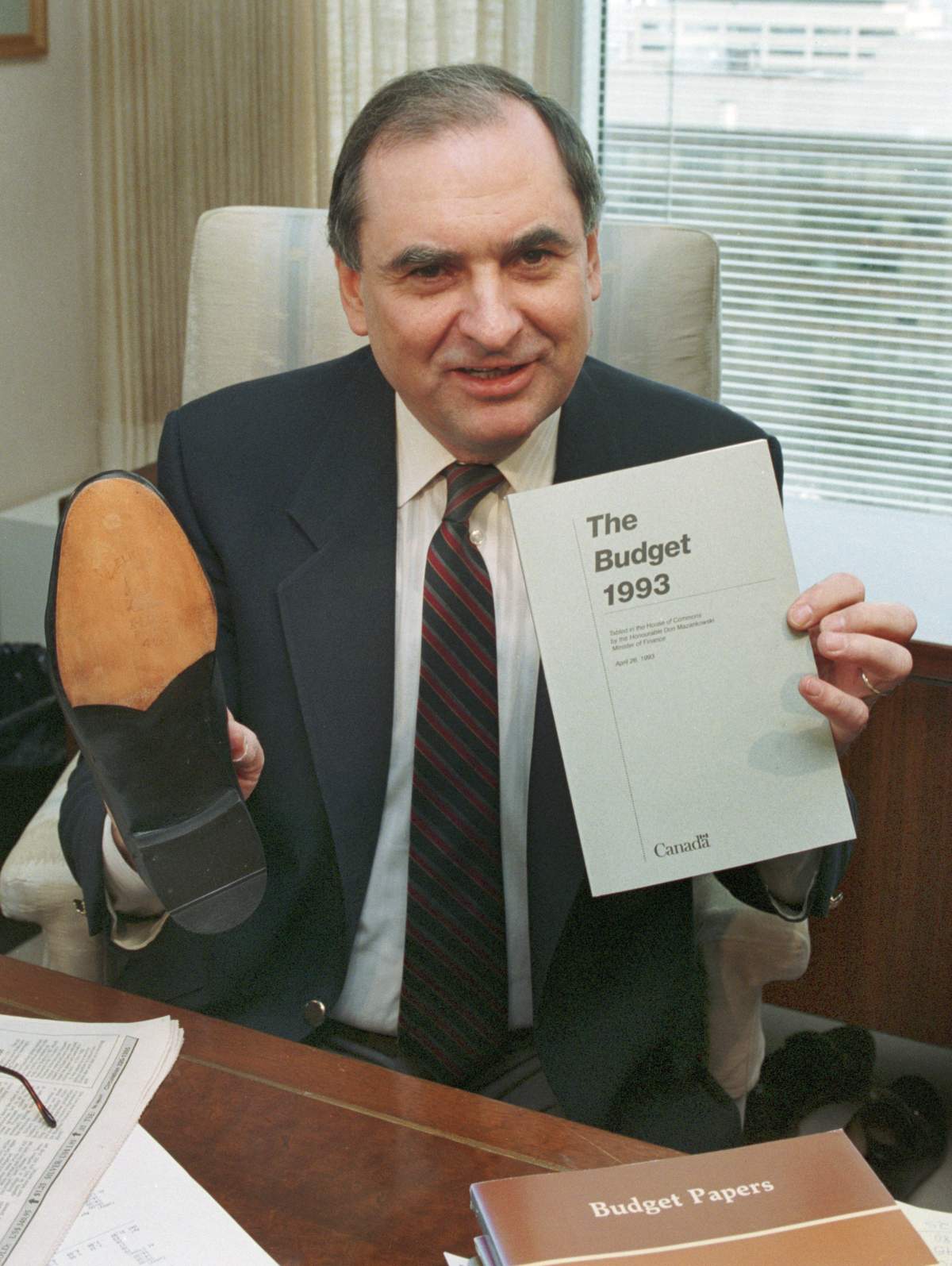 Finance Minister Don Mazankowski displays a copy of the budget brief along with his resoled shoes in his office in Ottawa on April 16, 1993.