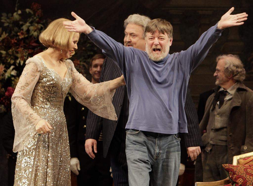 Conductor Andrew Davis, right, raises his arms as he takes a bow, accompanied by Renee Fleming, and Peter Rose, center, during the final dress rehearsal of Richard Strauss's "Capriccio" in the Metropolitan Opera at New York's Lincoln Center, March 25, 2011. Davis, the acclaimed British conductor who was music director of the Lyric Opera of Chicago and orchestras on three continents, has died. He was 80. 