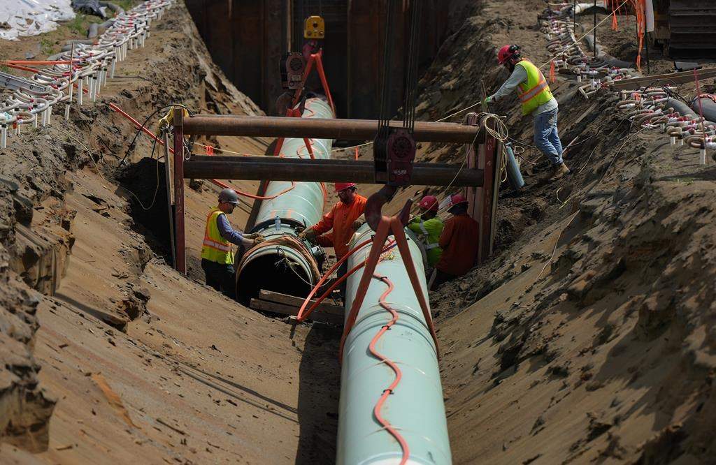 Workers lay pipe during construction of the Trans Mountain pipeline in Abbotsford, B.C., on Wednesday, May 3, 2023.