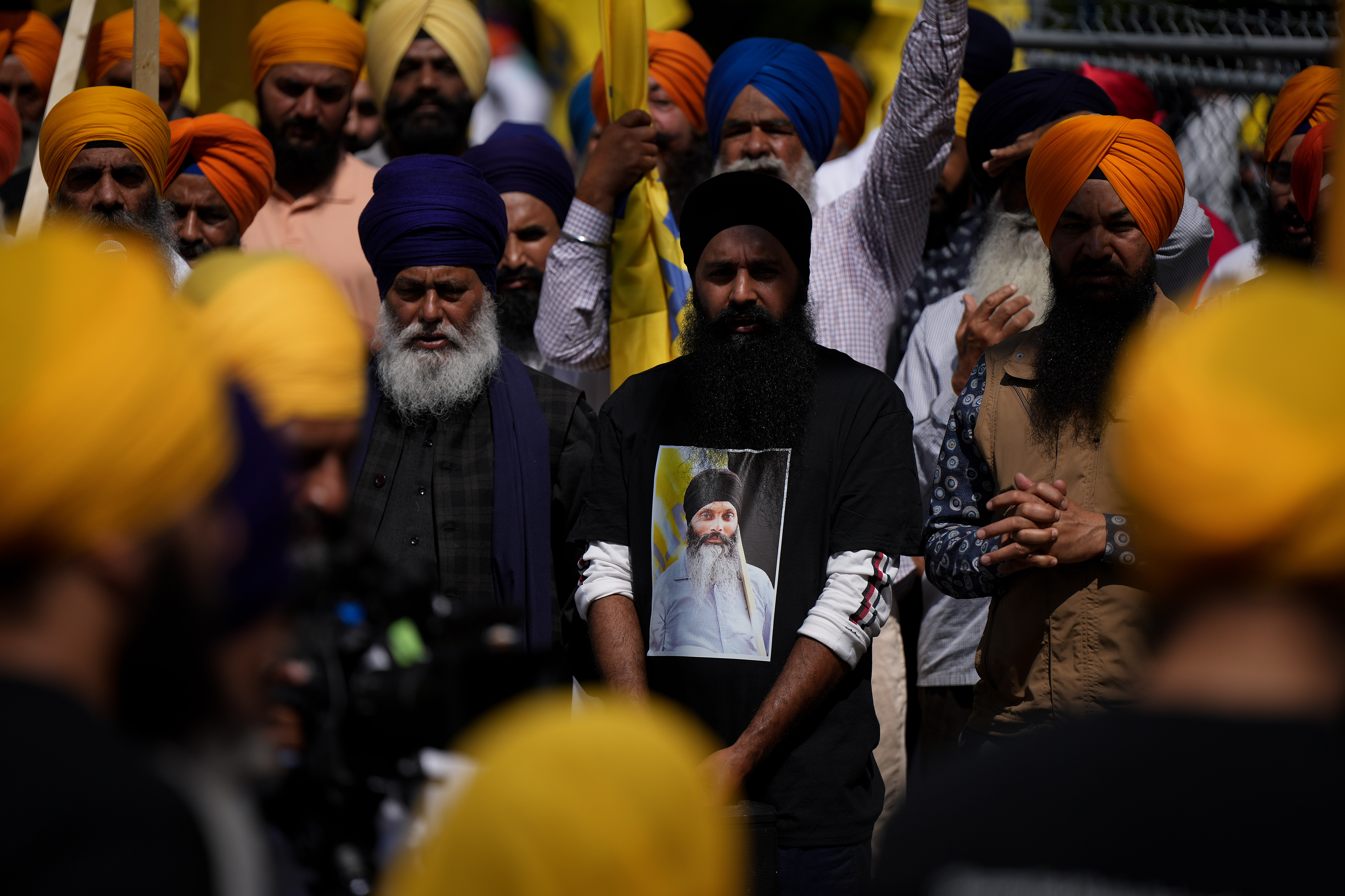 Mourner wears a t-shirt bearing a photograph of Hardeep Singh Nijjar, Surrey, B.C., June 25, 2023. THE CANADIAN PRESS/Darryl Dyck.