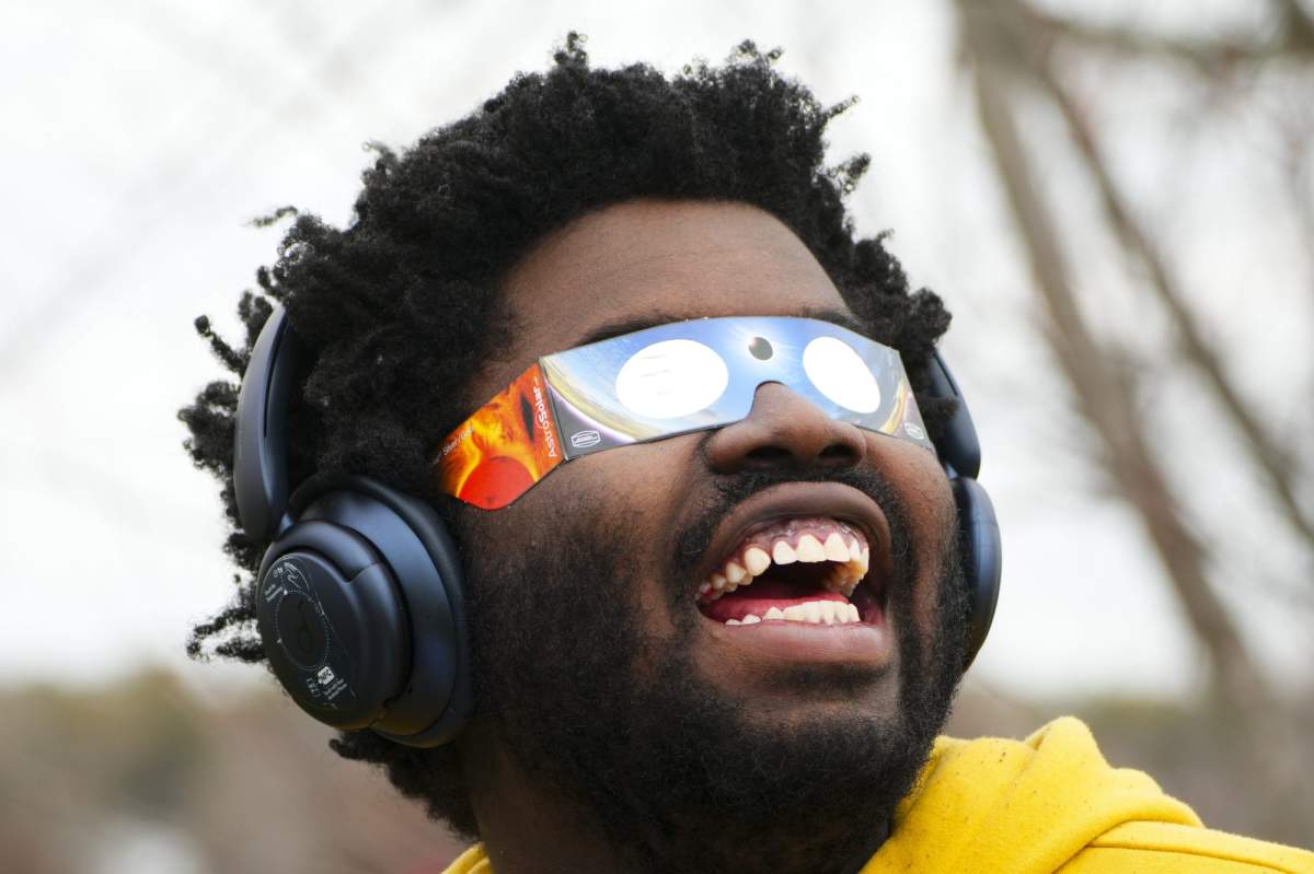 Didier Timothy-Mondesir watches the solar eclipse from Prince Edward County, Ont., Monday, April 8, 2024. THE CANADIAN PRESS/Sean Kilpatrick