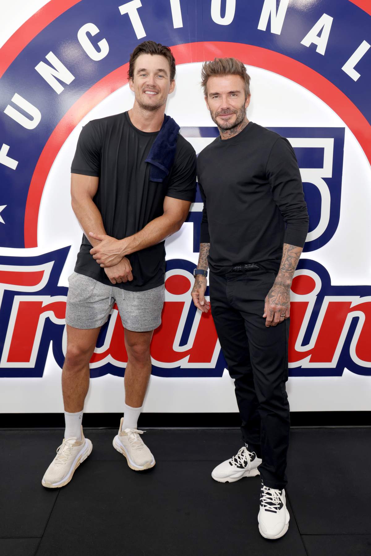 David Beckham and Tyler Cameron in front of an F45 Training sign.