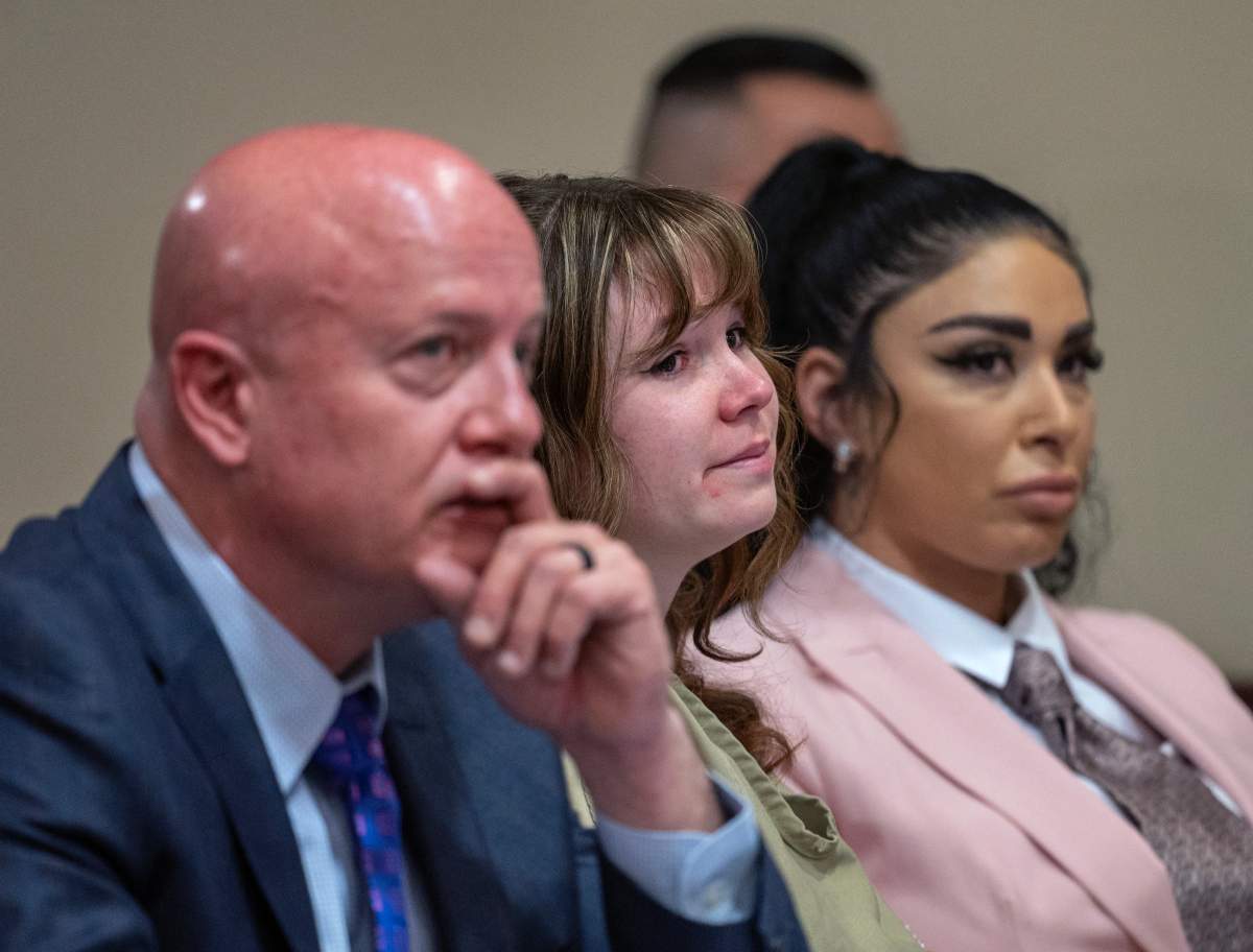 Hannah Gutierrez-Reed in between lawyer Jason Bowles and paralegal Carmella Sisneros. Gutierrez-Reed appears to be crying.