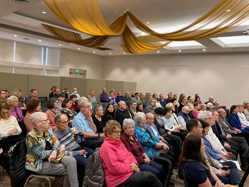A large crowd of people sitting in a room.