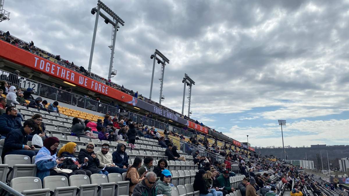 People gathered in stands on a cloudy day.