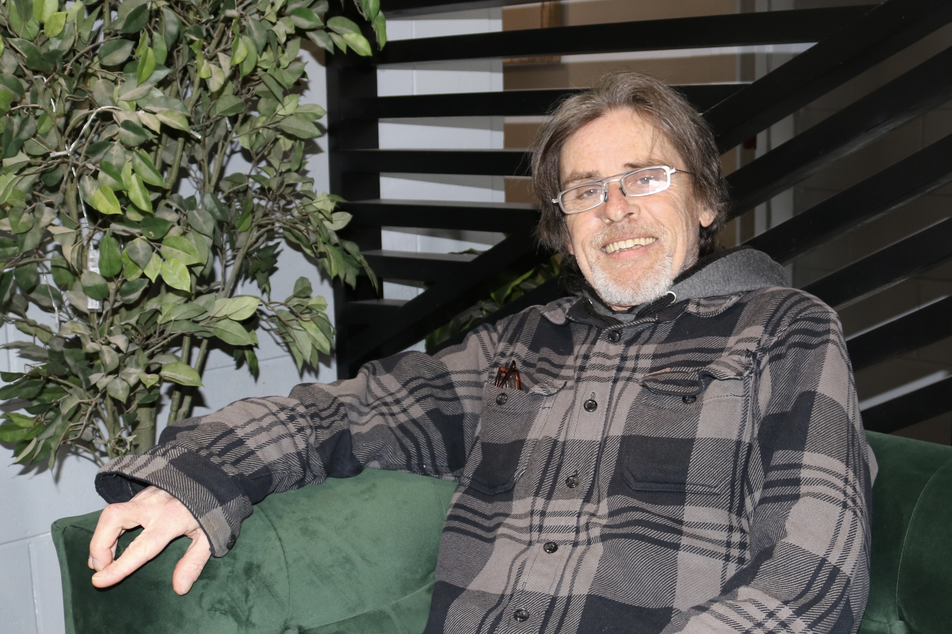 Robert Quinn, 61, from Barrie, Ont, sitting on a green couch.