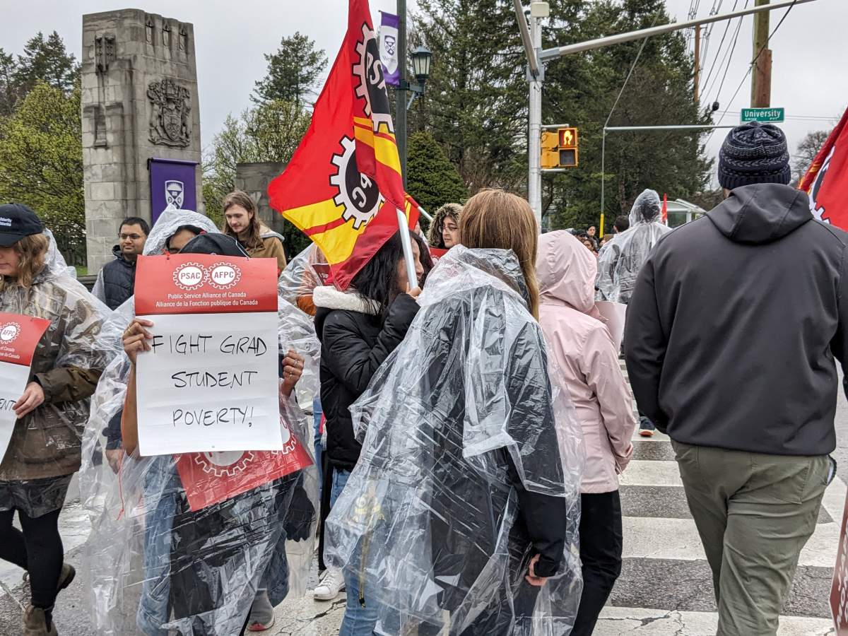 An image of people picketing on a rainy day.