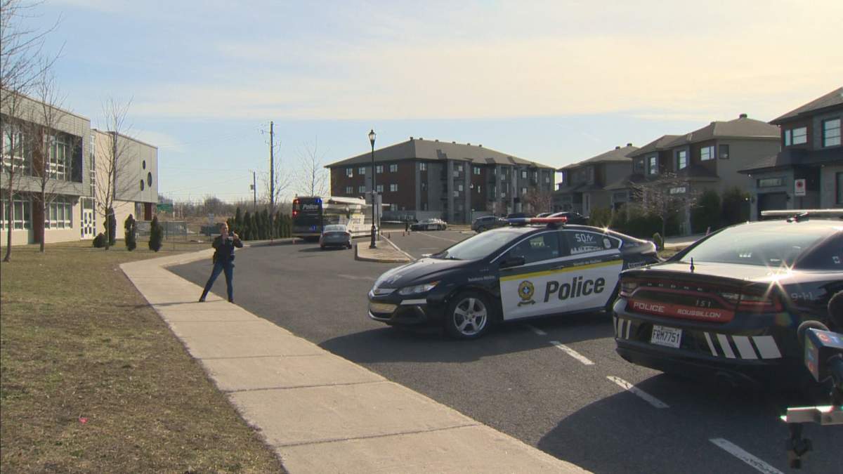 A police cruiser is seen in front of a residential building.