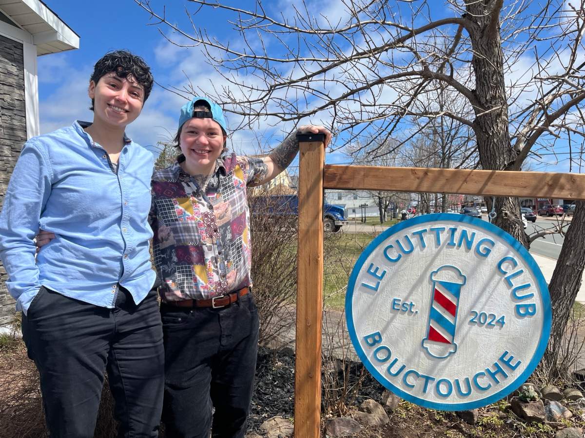 Sara Idris and Jesse Mathieu stand next to Le cutting club's sign