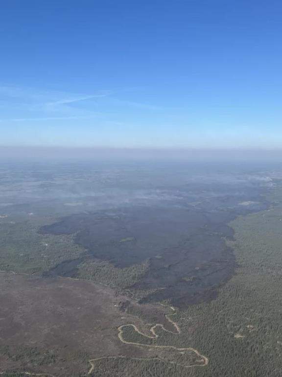A massive swathe of burned forest is seen as a wildfire designated MWF017 by the Alberta Wildfire Service, top right, continues to burn near Ft. McMurray, Alta., in a Saturday, May 11, 2024, handout photo.
