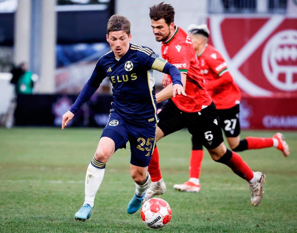 Vancouver Whitecaps FC midfielder Ryan Gauld, left, controls the ball as Cavalry FC midfielder Charlie Trafford chases him during second half soccer action in the Canadian Championship quarterfinal, leg 1, in Calgary, Tuesday, May 7, 2024.