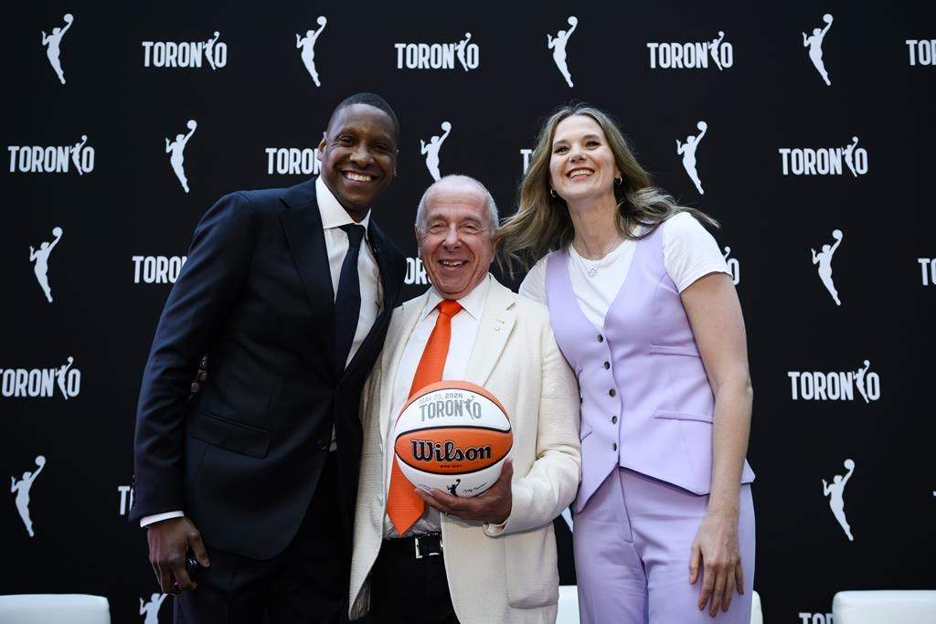 Larry Tanenbaum of Kilmer Sports Ventures, middle, joins Toronto Raptors president Masai Ujiri, and WNBA Toronto team president Teresa Resch pose for a photo as they announced Toronto WNBA franchise, in Toronto on Thursday, May 23, 2024. THE CANADIAN PRESS/Christopher Katsarov
