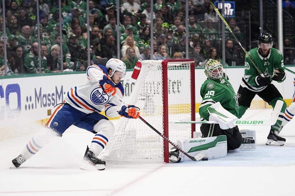 Dallas Stars goaltender Jake Oettinger (29) blocks a shot by Edmonton Oilers centre Mattias Janmark, left, as Stars' Ryan Suter (20) looks on during the second period in Game 2 of the Western Conference finals in the NHL hockey Stanley Cup playoffs Saturday, May 25, 2024, in Dallas.