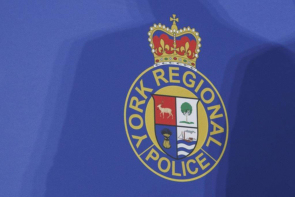 Police have charged a second man after a series of alleged shootings at at four movie theatres across the Greater Toronto Area. A shadow is cast over the logo of the York Regional Police during a press conference at their headquarters in Aurora, Ont., Wednesday, Jan. 31, 2024. 