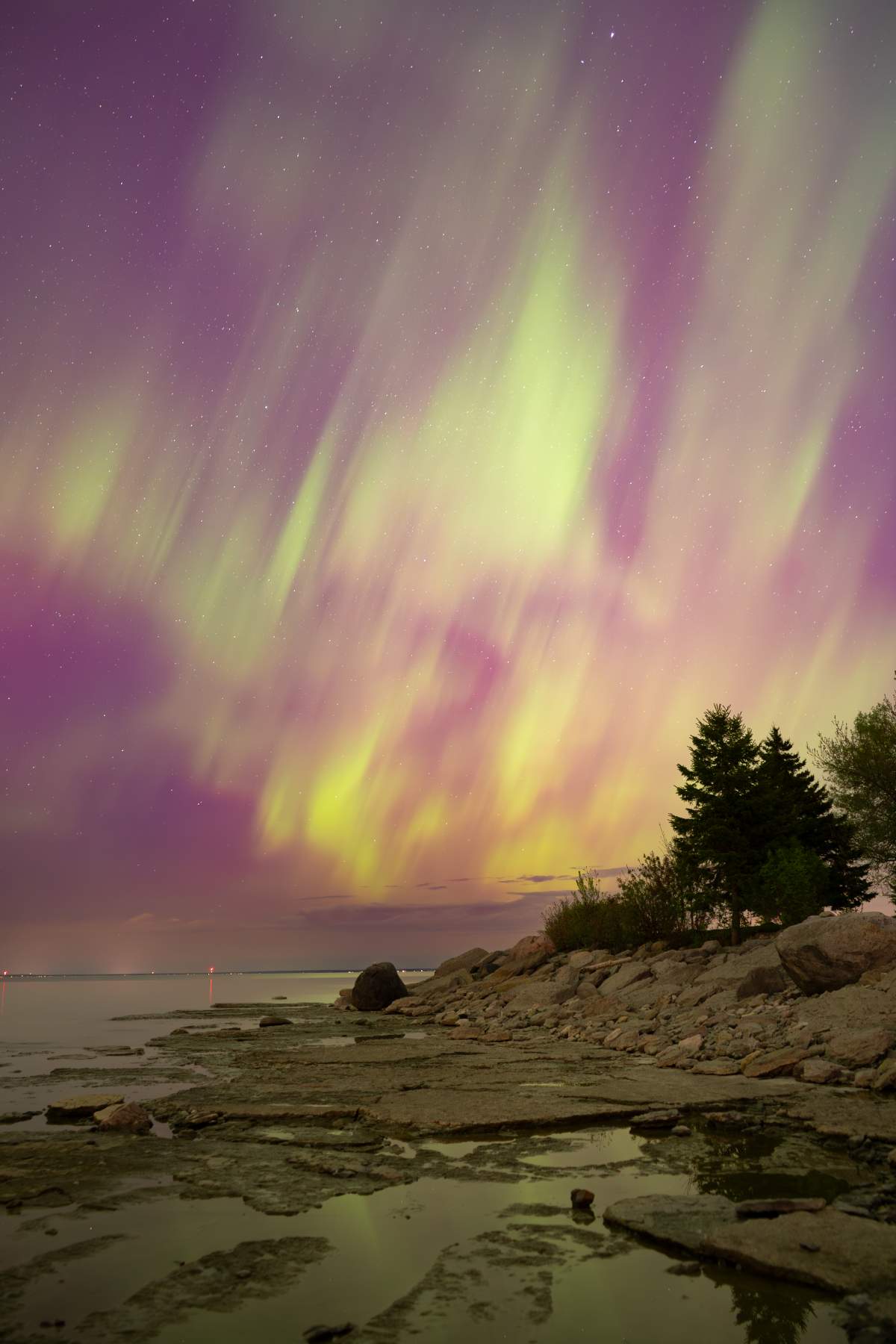 View of northern lights on Georgian Bay in the sky at Sunset Point Beach in Collingwood, Ont. on the night of May 10, 2024