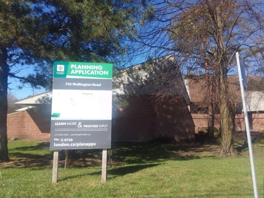 A picture of a building with a zoning sign in front of it.