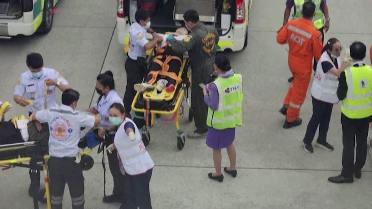 Passengers of Singapore Airlines flight SQ321 being stretchered away by emergency responders.