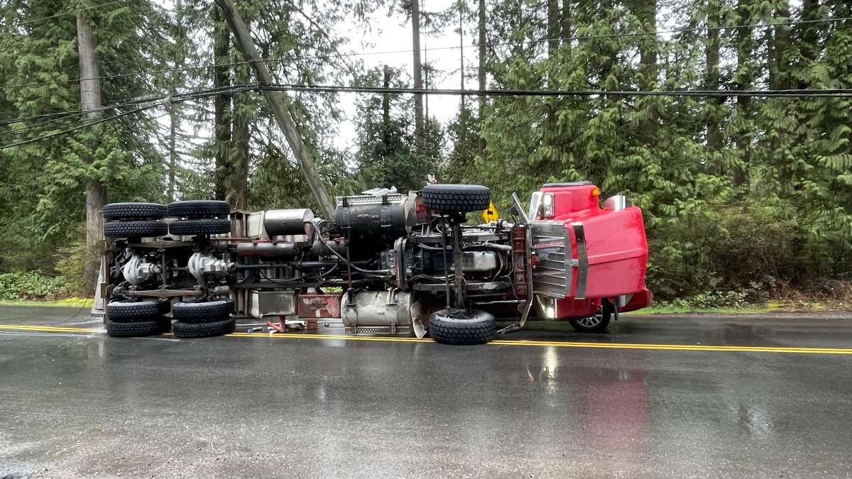 This picture shows the dump truck flipped over onto its side.
