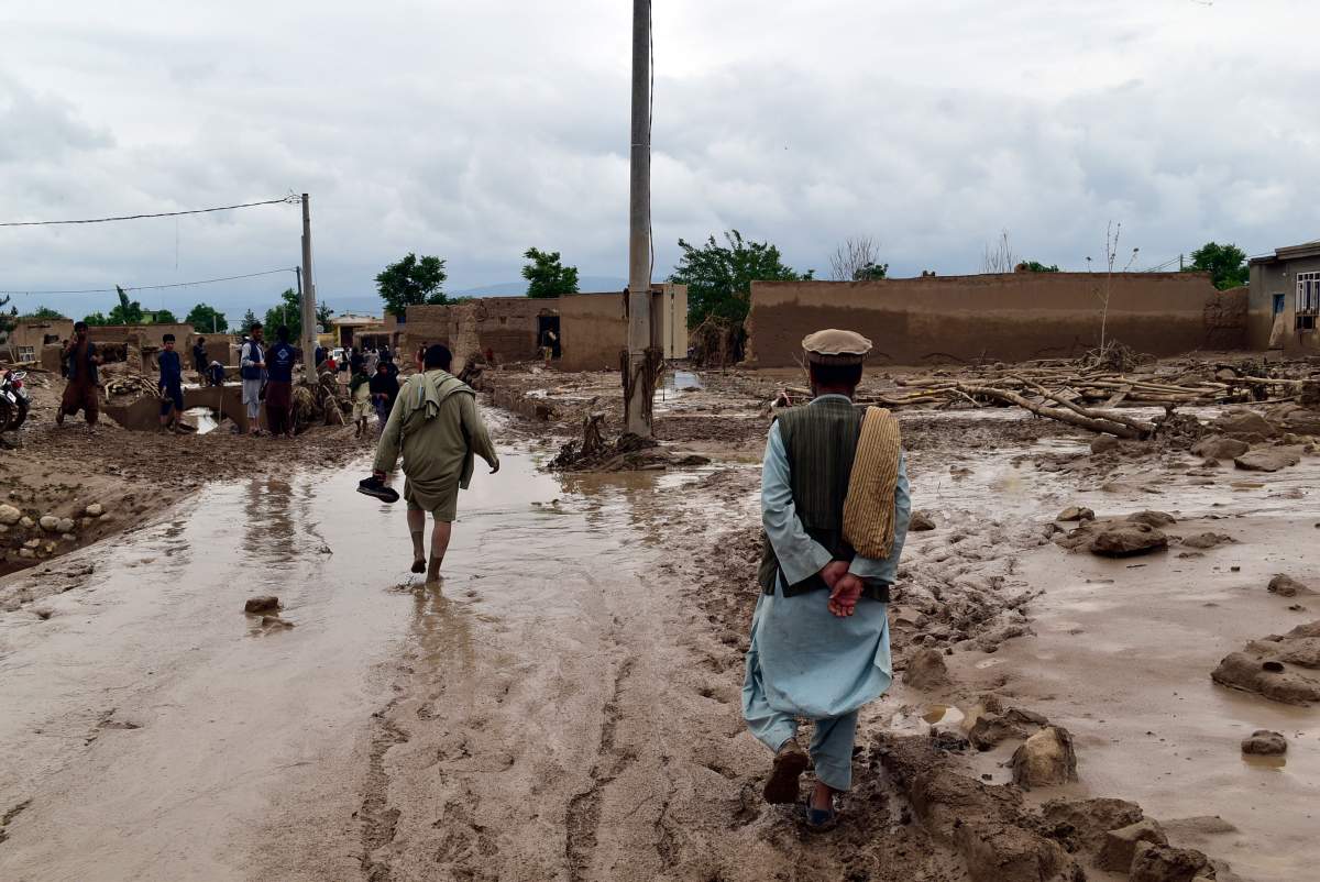 People are seen near to their damaged homes after heavy flooding in Baghlan province in northern Afghanistan Saturday, May 11, 2024