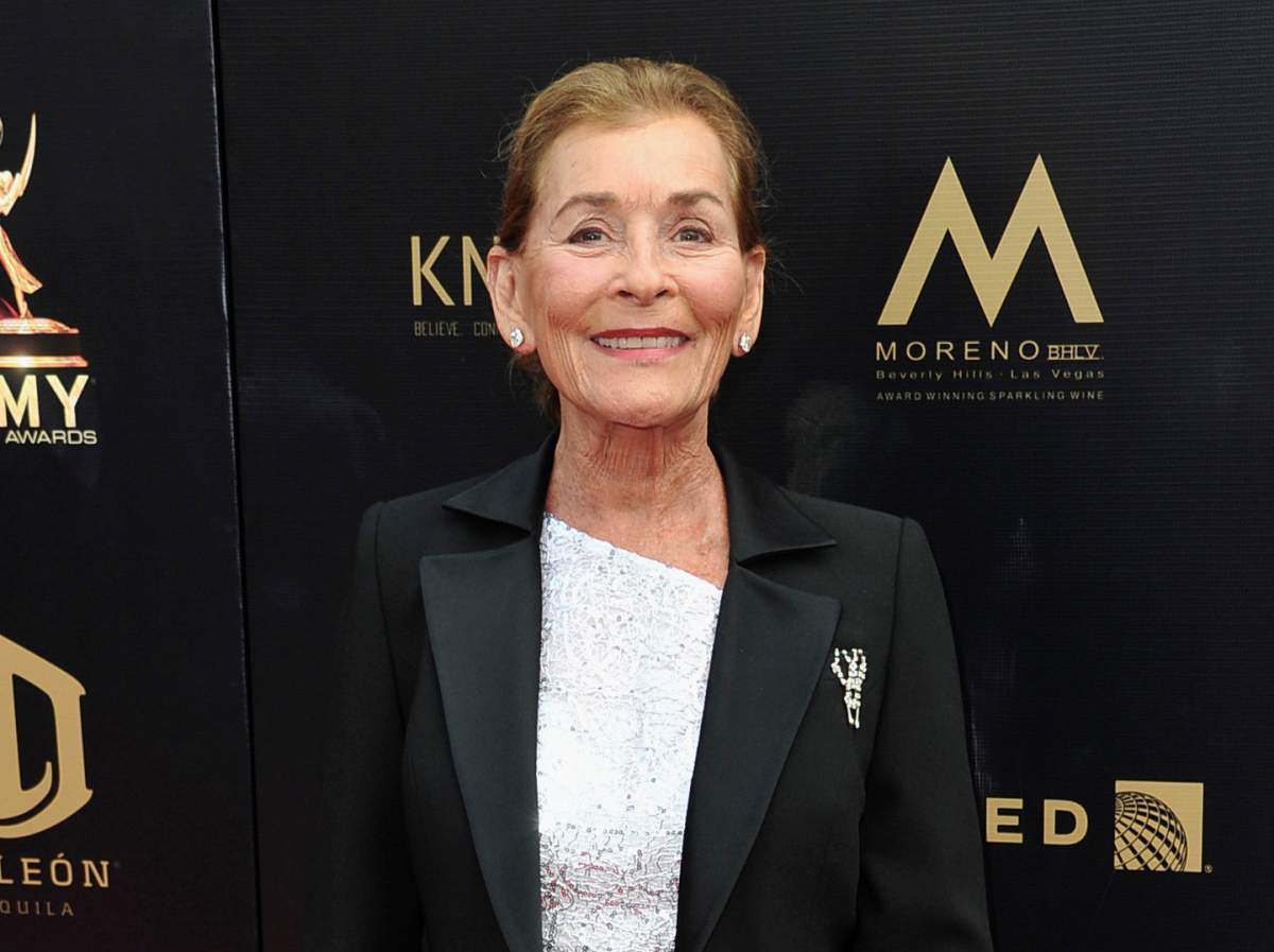Judge Judy Sheindlin smiling in a black blazer and white top.
