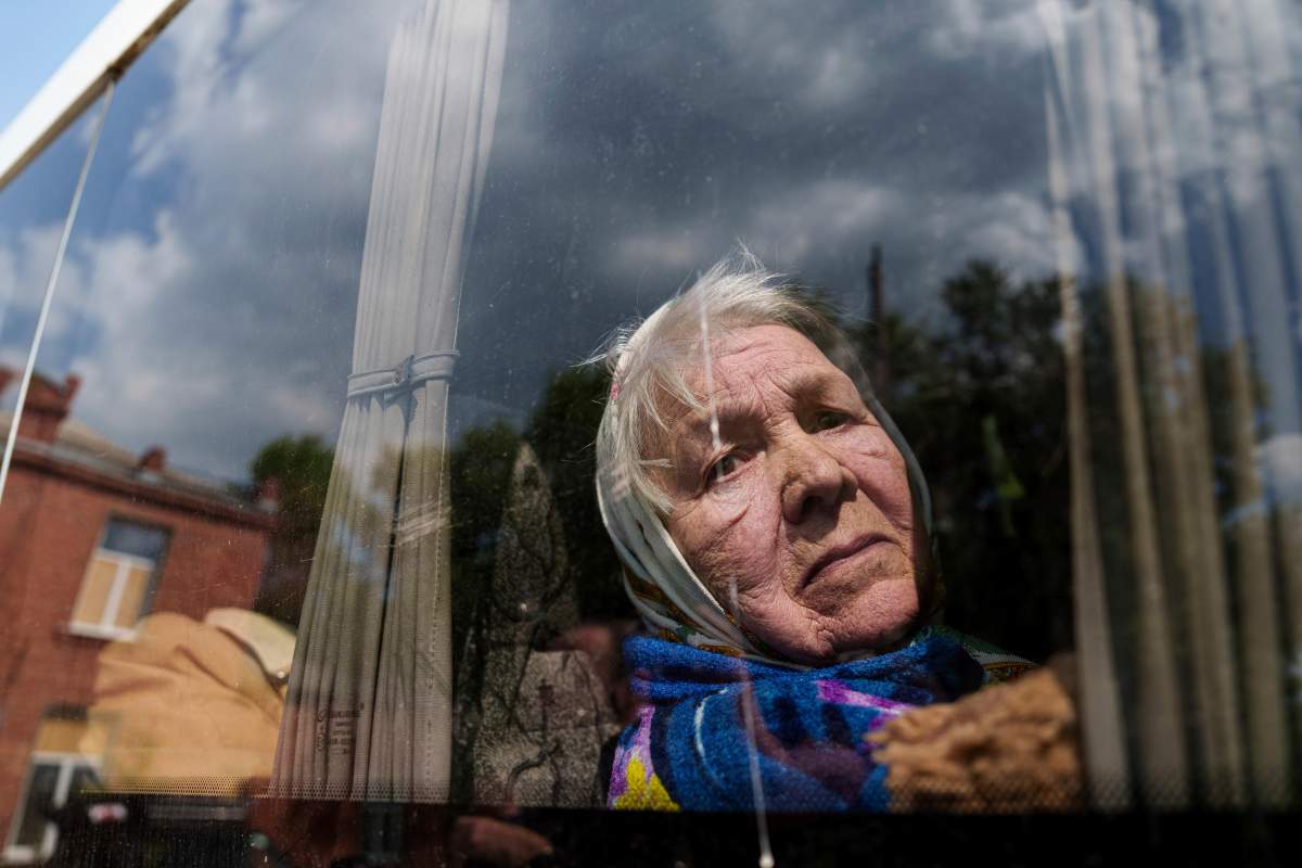 Liudmila, 85, looks through the window of a bus after being evacuated from Vovchansk, Ukraine, Sunday, May 12, 2024. Her husband was killed in their house after a Russian airstrike on the city.