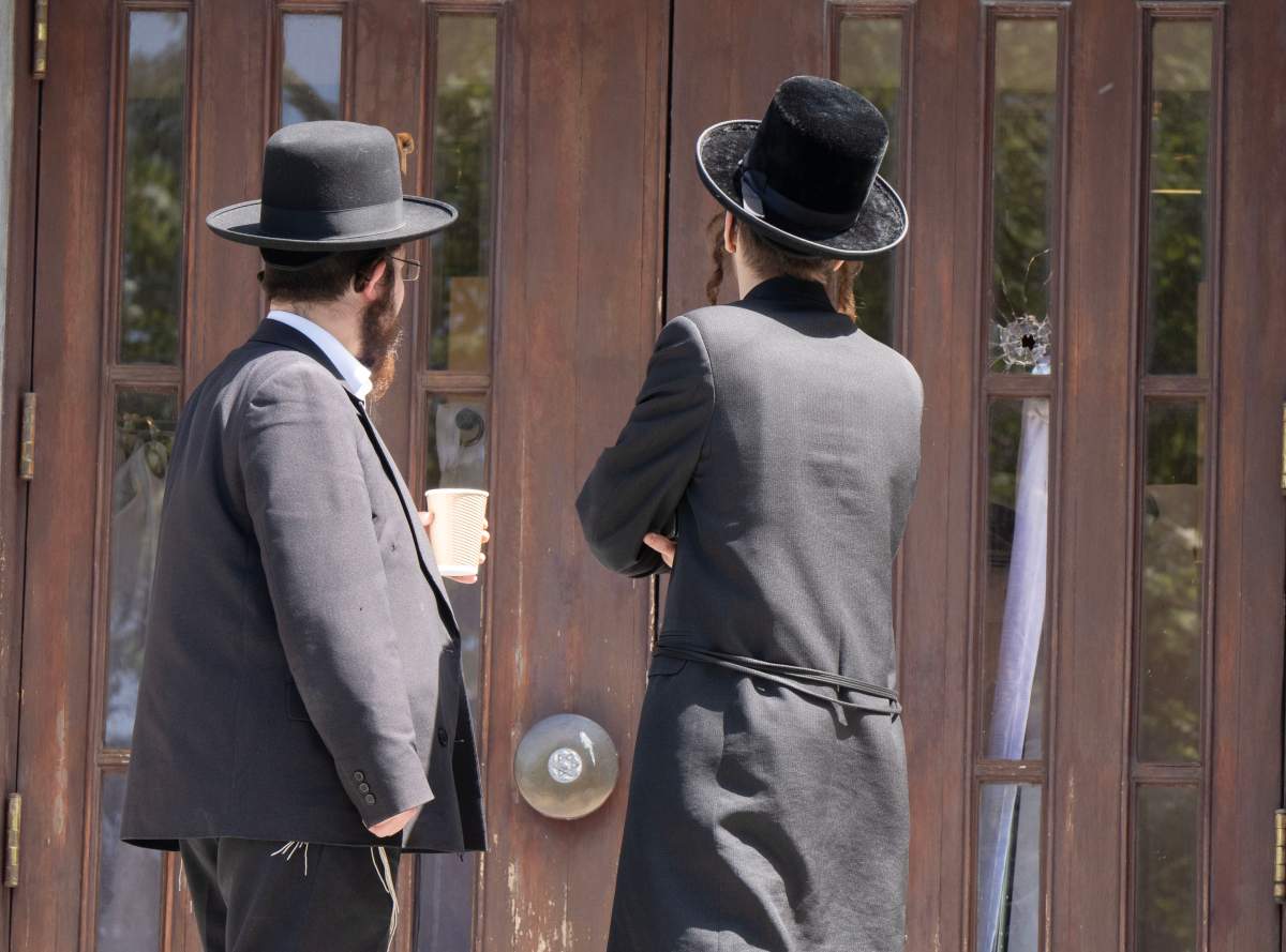 Two men look at a bullet hole in the door of the Bell Yeshiva Katana school Thursday, May 30, 2024 in Montreal.