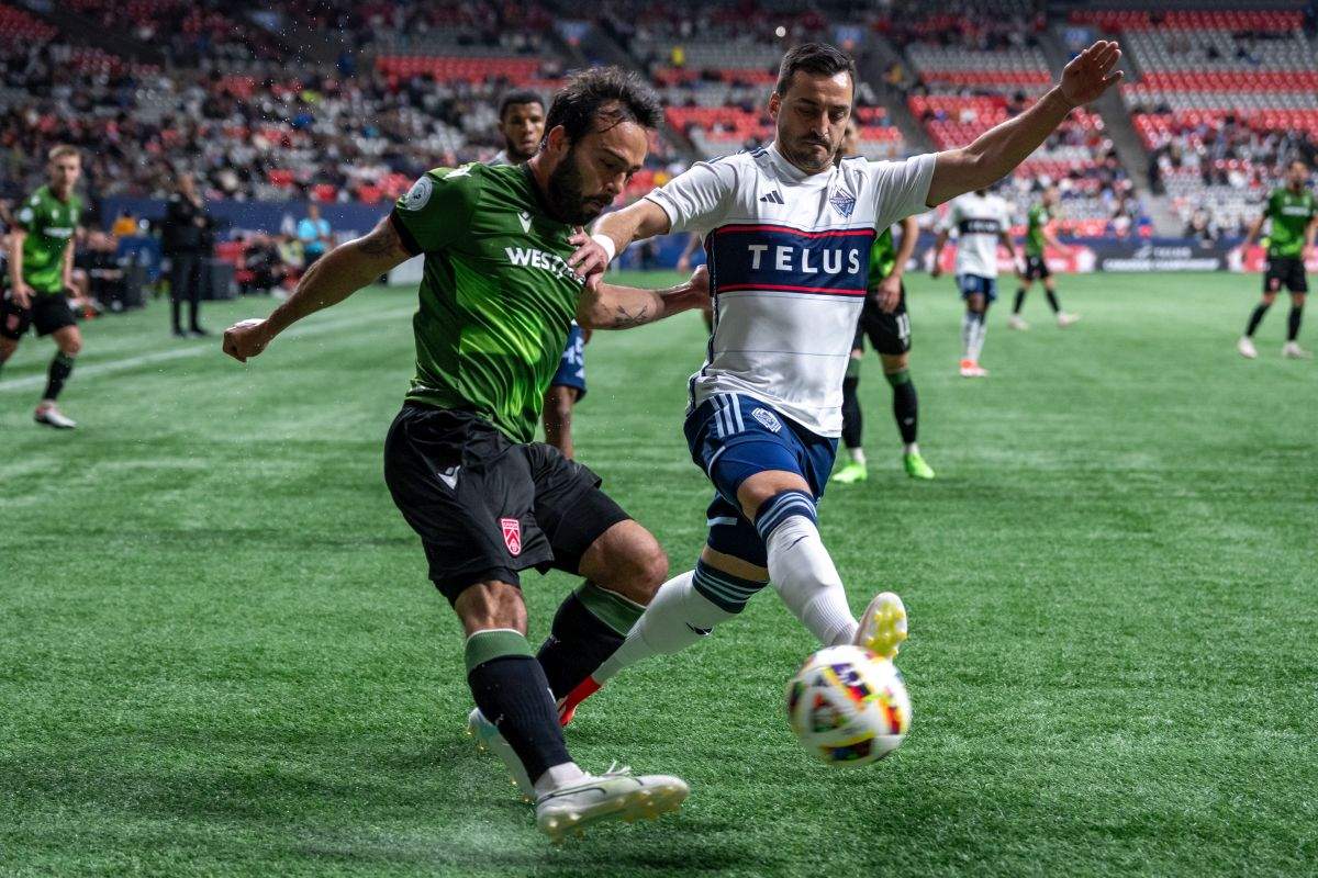 Cavalry FC's Sergio Camargo, left, and Vancouver Whitecaps' Luís Martins, right, vie for the ball during the first half of a Canadian Championship quarterfinal soccer match, in Vancouver, on Tuesday, May 21, 2024.