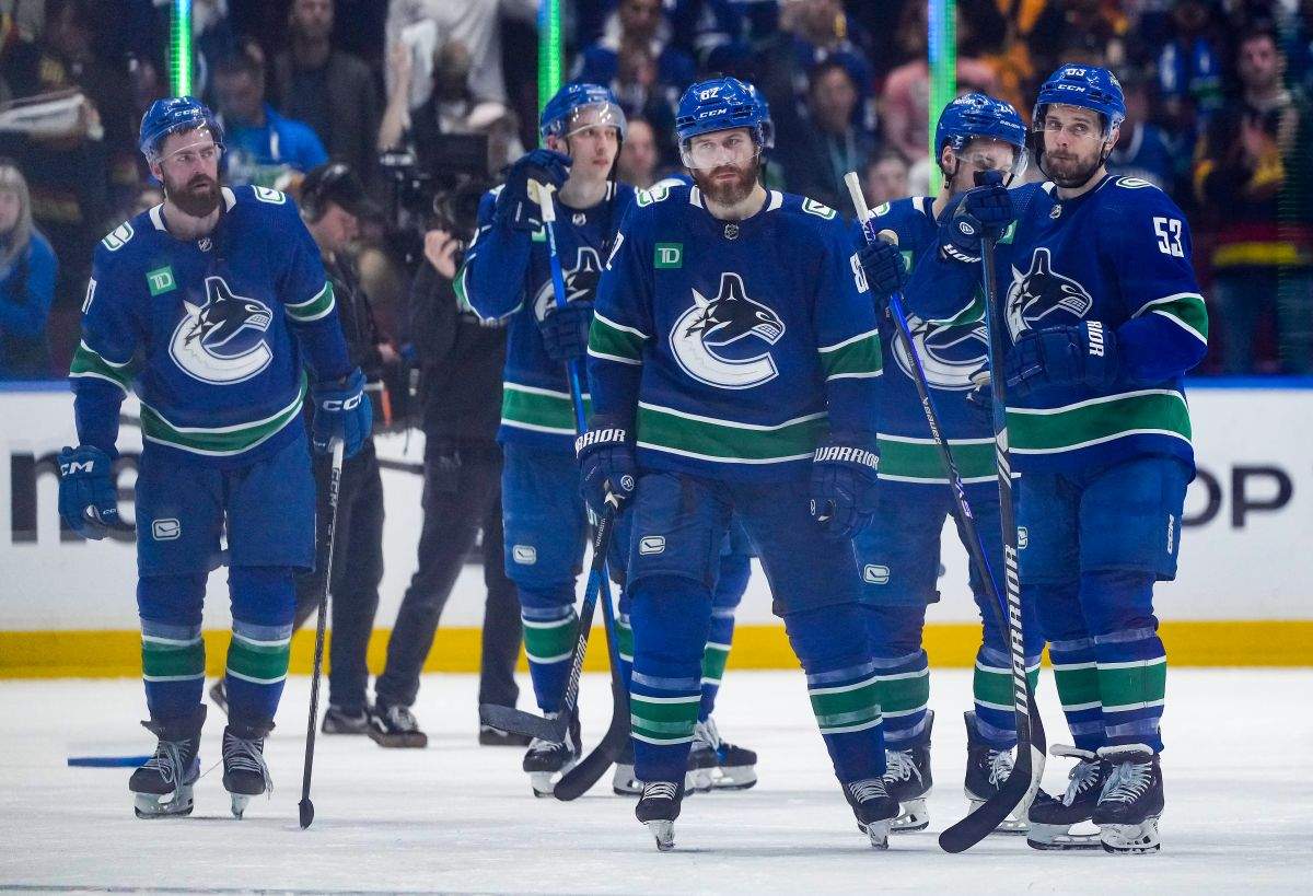 Vancouver Canucks' Ian Cole, front centre, Teddy Blueger, front right, Filip Hronek, back left, and Ilya Mikheyev, back second left, stand on the ice after Vancouver was defeated by the Edmonton Oilers 3-2 during Game 7 of an NHL hockey Stanley Cup second-round playoff series, in Vancouver, on Monday, May 20, 2024.
