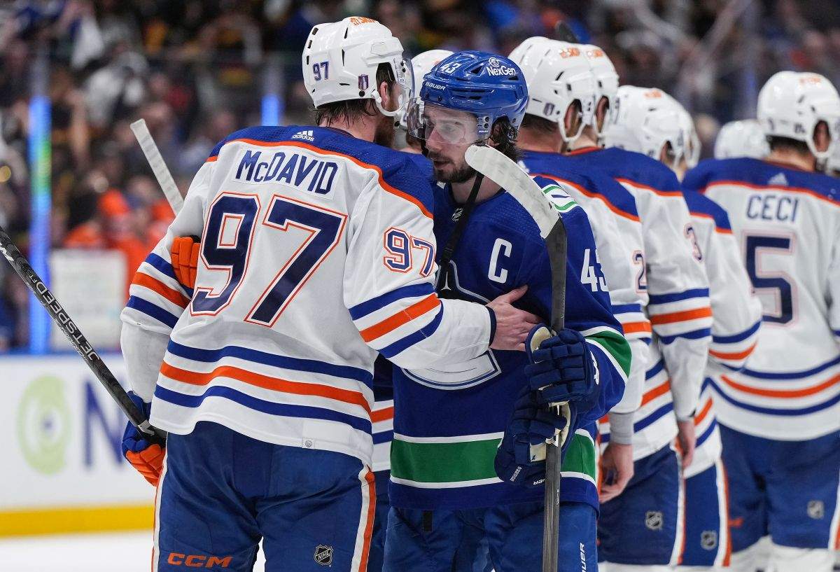 Vancouver Canucks' Quinn Hughes, front right, and Edmonton Oilers' Connor McDavid talk while shaking hands after Edmonton defeated Vancouver during Game 7 of an NHL hockey Stanley Cup second-round playoff series, in Vancouver, on Monday, May 20, 2024.