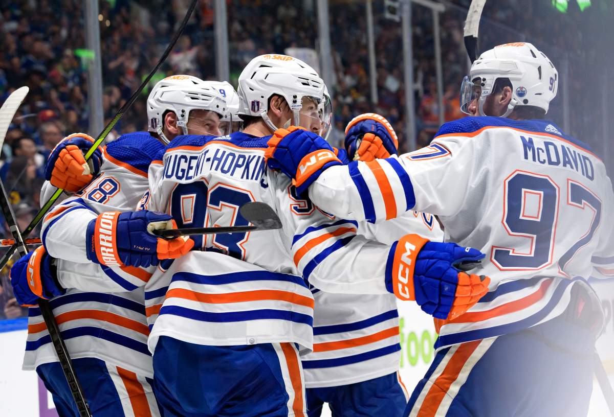 Ryan Nugent-Hopkins #93 of the Edmonton Oilers is congratulated by teammates Connor McDavid #97 and Zach Hyman #18 after scoring on the Vancouver Canucks during the second period in Game Seven of the Second Round of the 2024 Stanley Cup Playoffs at Rogers Arena on May 20, 2024 in Vancouver, British Columbia, Canada.