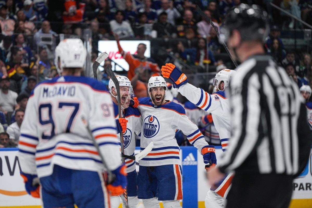Edmonton Oilers' Zach Hyman, back from left to right, Ryan Nugent-Hopkins, Evan Bouchard, Mattias Ekholm and Connor McDavid, front left, celebrate Hyman's goal against the Vancouver Canucks during the second period in Game 7 of an NHL hockey Stanley Cup second-round playoff series, in Vancouver, on Monday, May 20, 2024.