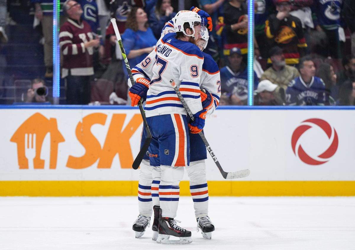 Edmonton Oilers' Connor McDavid, front, and Leon Draisaitl celebrate after Edmonton defeated the Vancouver Canucks 3-2 during Game 7 of an NHL hockey Stanley Cup second-round playoff series, in Vancouver, on Monday, May 20, 2024.