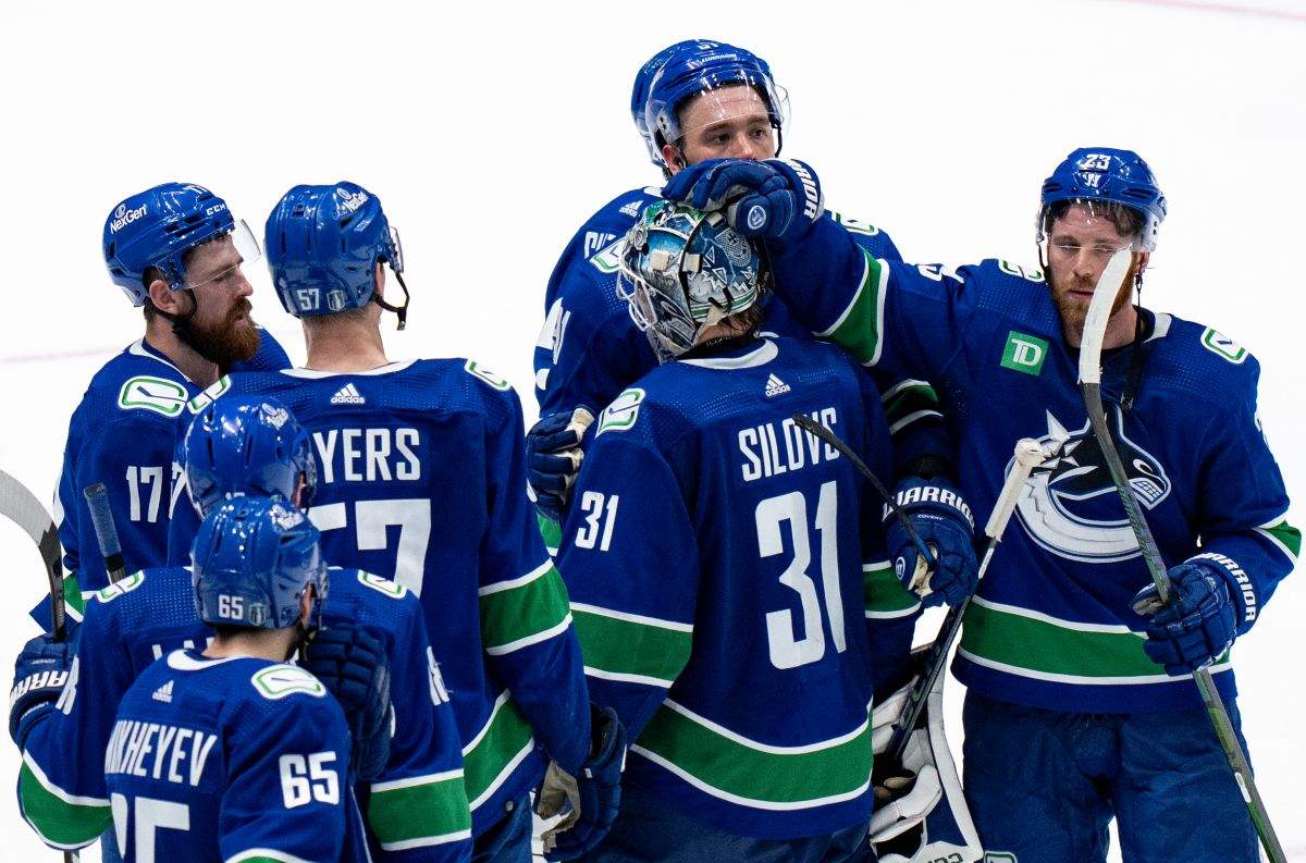 Vancouver Canucks players surround their goalie Arturs Silovs after they lost against the Edmonton Oilers in Game 7 of an NHL hockey Stanley Cup second-round playoff series, in Vancouver, on Monday, May 20, 2024.