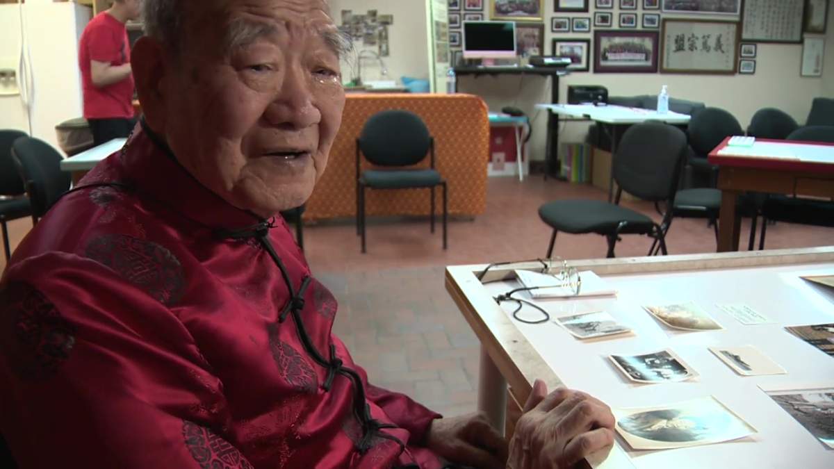 Hoy Sein Mah, 90, with photos of his family.