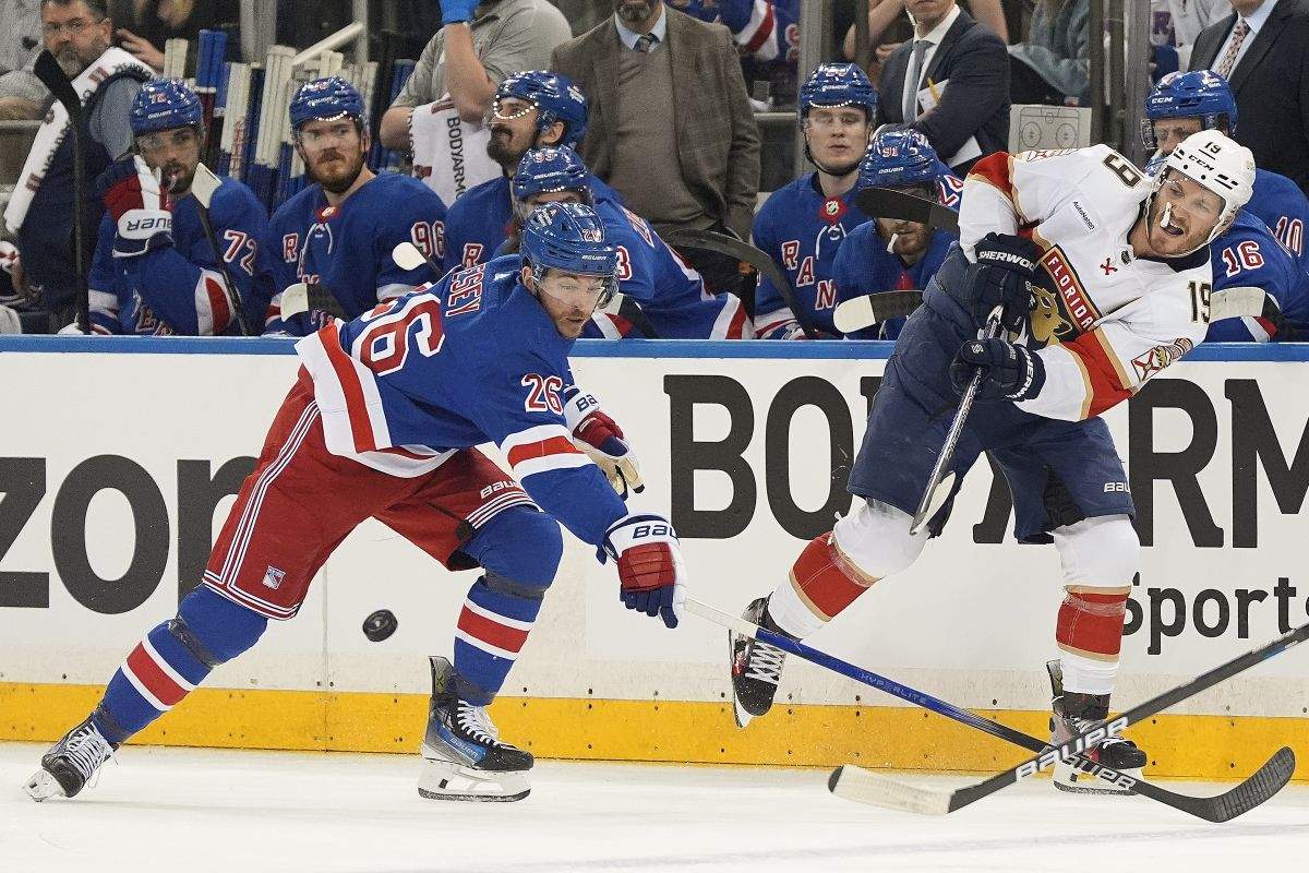 Florida Panthers left wing Matthew Tkachuk (19) passes the puck against New York Rangers left wing Jimmy Vesey (26) during the first period of Game 1 of the NHL hockey Eastern Conference Stanley Cup playoff finals, Wednesday, May 22, 2024, in New York.