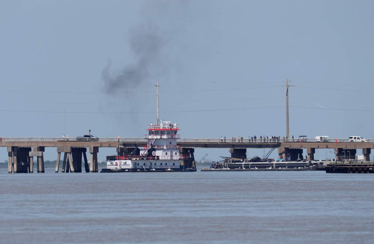 A tugboat works to maneuver a barge away from the Pelican Island Bridge in Galveston, Texas, on Wednesday, May 15, 2024, after the barge crashed into the bridge shutting down the only road access to and from the island. (Jennifer Reynolds/The Galveston County Daily News via AP)