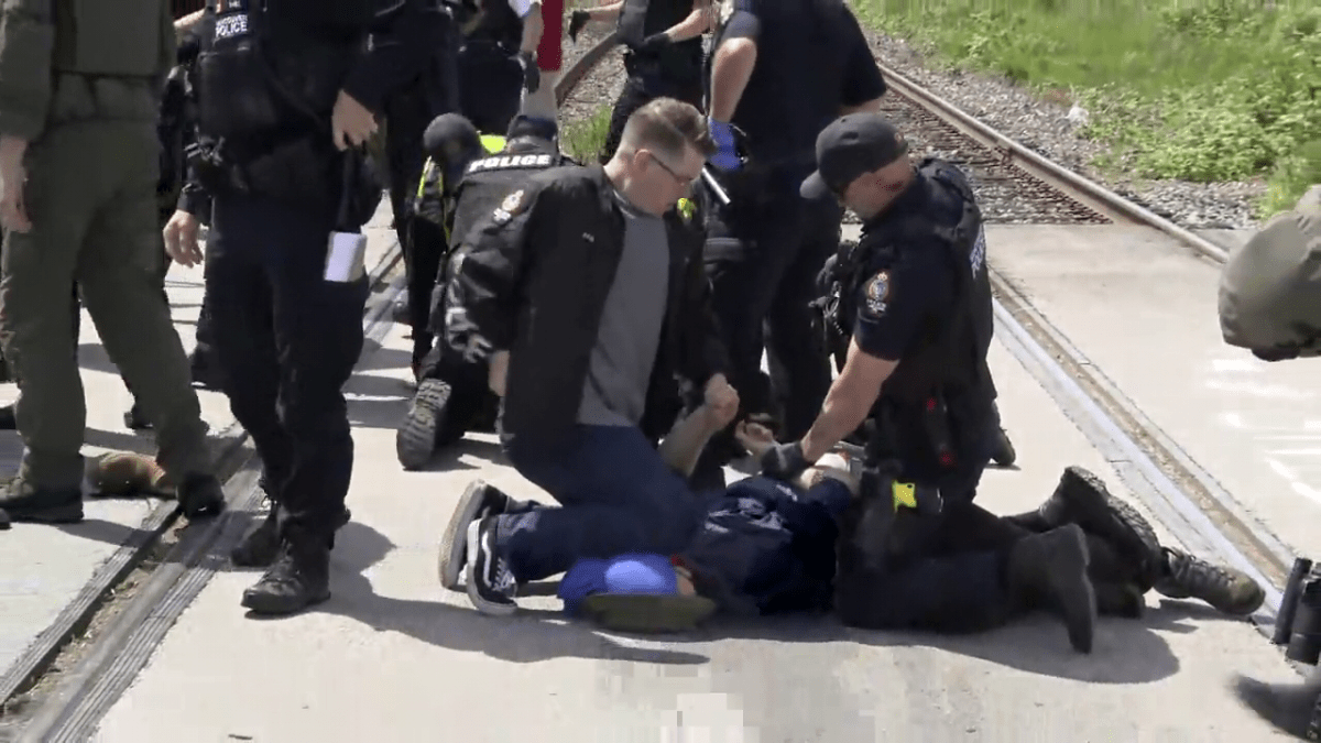 Vancouver police make an arrest at a protest blocking a rail line in East Vancouver on Friday, May 31, 2024. 