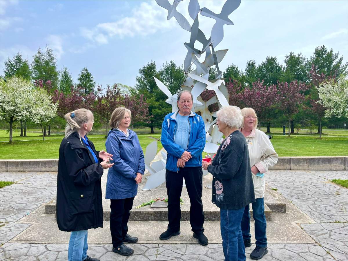 Family of Const. Chris Garrett gather at the memorial statue in Cobourg, Ont. on May 15, 2024. Garrett was killed in the line of duty on May 15, 2004.