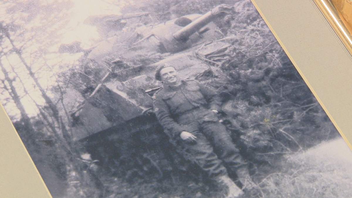 Van Roon leaning against a Sherman tank during the Second World War.