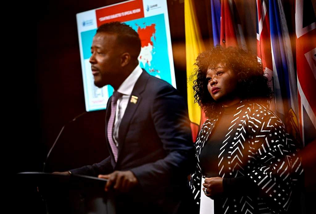 Bernadeth Betchi, CHRC employee and representative plaintiff, listens as Nicholas Marcus Thompson, executive director of the Black Class Action Secretariat, speaks at a news conference on the Global Alliance of National Human Rights Institutions' “Special Review” of the accreditation of the Canadian Human Rights Commission, on Parliament Hill, in Ottawa, Monday, June 10, 2024. 