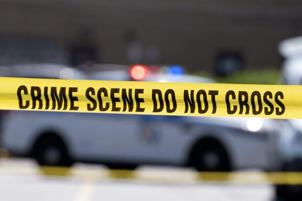 A third person has been charged in the investigation of a 27-year-old woman found dead earlier this month in southwestern Ontario. Police tape blocks off a crime scene July 13, 2021, in Baltimore, Md. 