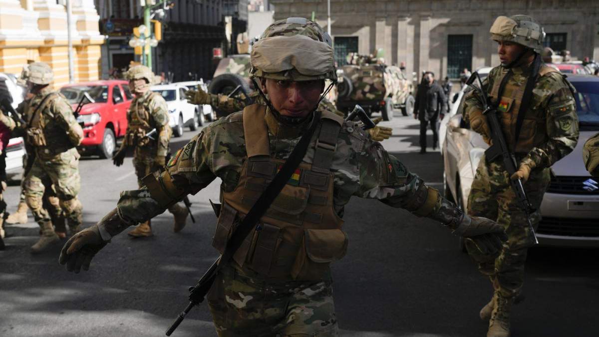 A soldier gestures for journalists to leave Plaza Murillo as soldiers gather near the presidential palace in Plaza Murillo in La Paz, Bolivia, Wednesday, June 26, 2024.