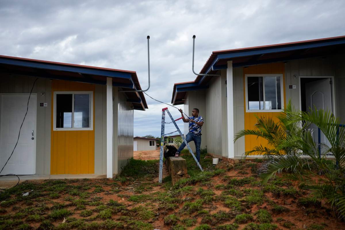 A worker pulls cables at new homes in Nuevo Carti on Panama’s Caribbean coast, Monday, May 27, 2024.