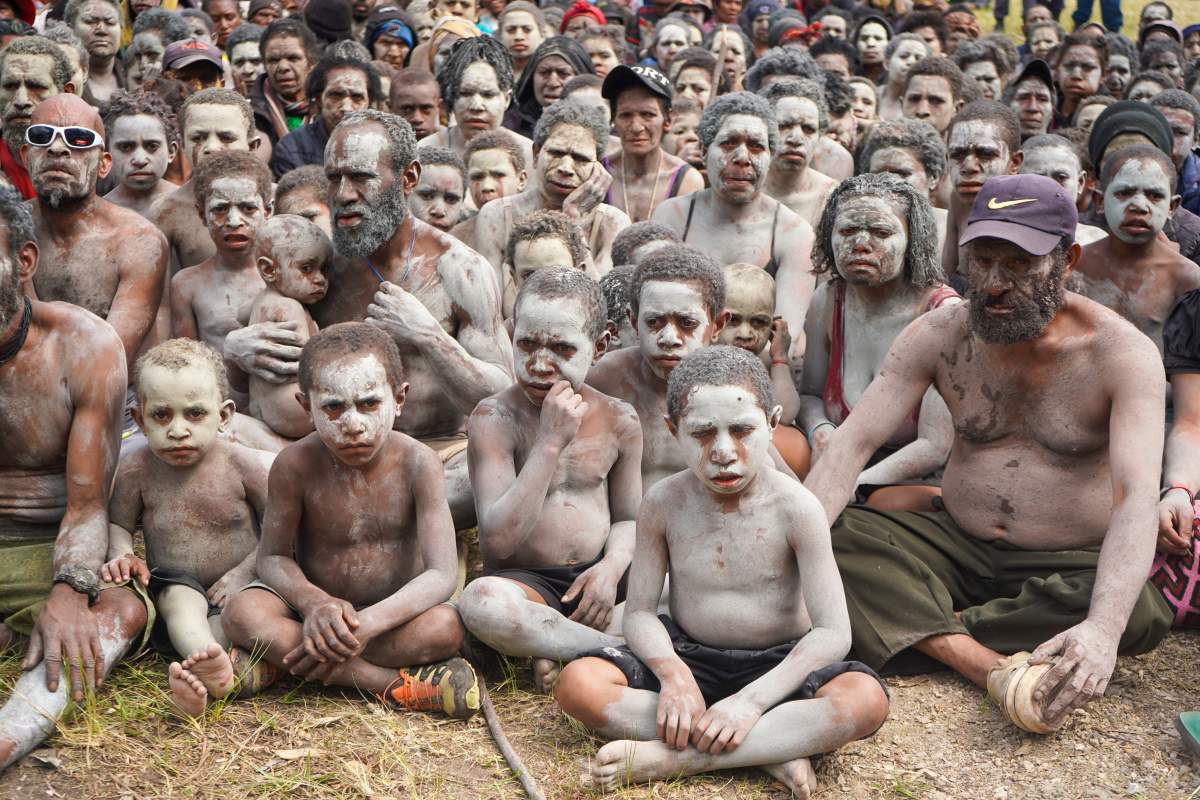 A group of survivors from the May 24 landslide in Inga Province, are smeared in mud as a sign of mourning, gather at an event where Prime Minister James Marape was to address them at Kaokalom village, in the highlands of Papua New Guinea, Friday May 31, 2024. Marape visited the site of a major landslide, which is estimated to have buried hundreds of villagers in the South Pacific island nation’s mountainous interior over a week ago and left the ground too unstable for heavy earthmoving machines to help clear up the mess. (Noreen Chambers,UNICEF PNG)