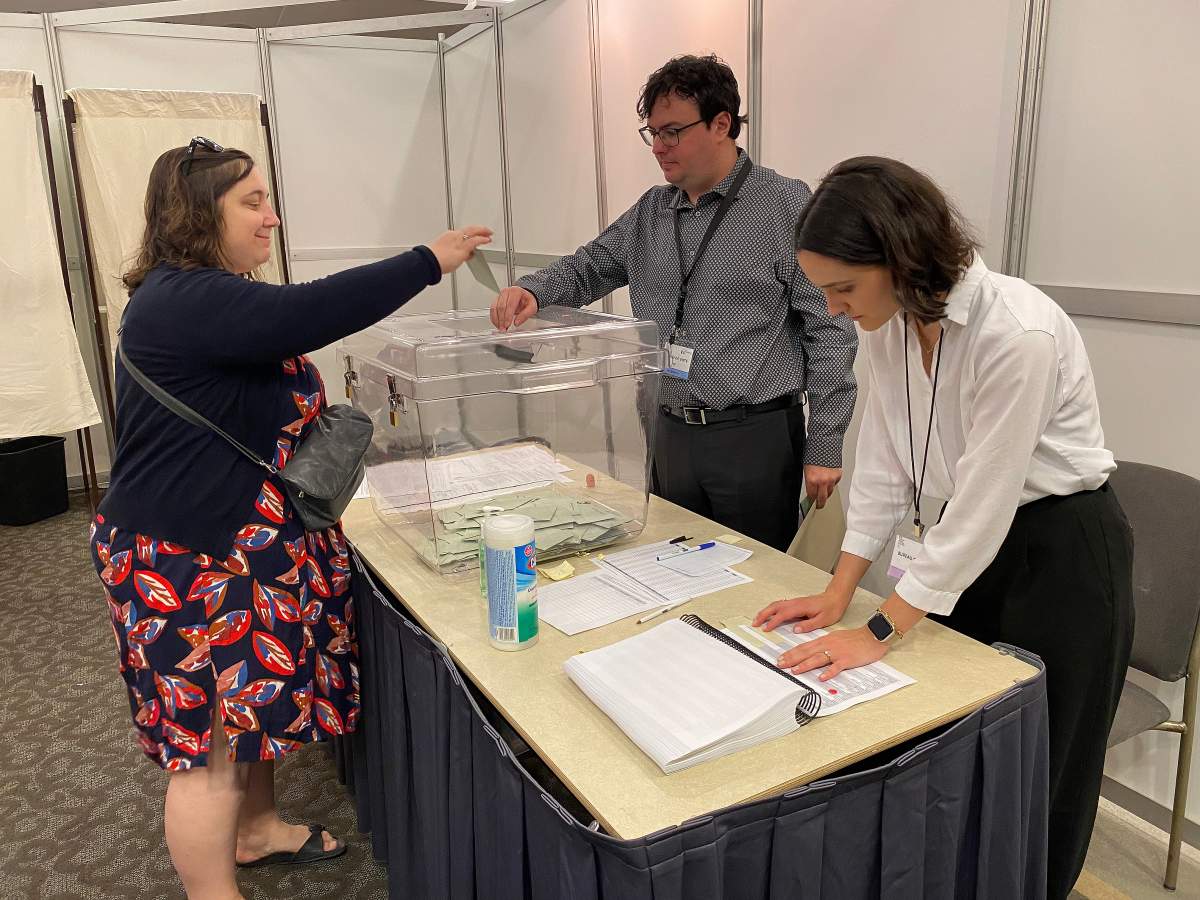 A French citizen, left, places their ballot in a ballot box as they turned out to vote in France’s national elections, at the Centre Mont-Royal in Montreal, Saturday, June 29, 2024.