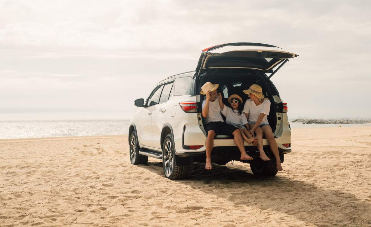Family on a road trip with their van stopped by the water